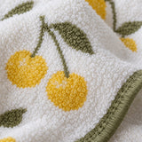 Close-up of the Cherry Print Cotton Washcloth's looped cotton terry, print and stitched green hem.