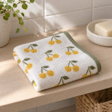 Cherry Print Cotton Washcloth folded on a bathroom shelf, ready for a face-washing routine.