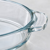Macro detail of the clear baking dish's thick glass rim and dotted handle grip.