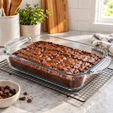 Rectangular glass baking dish with brownies cooling on a bright kitchen counter.