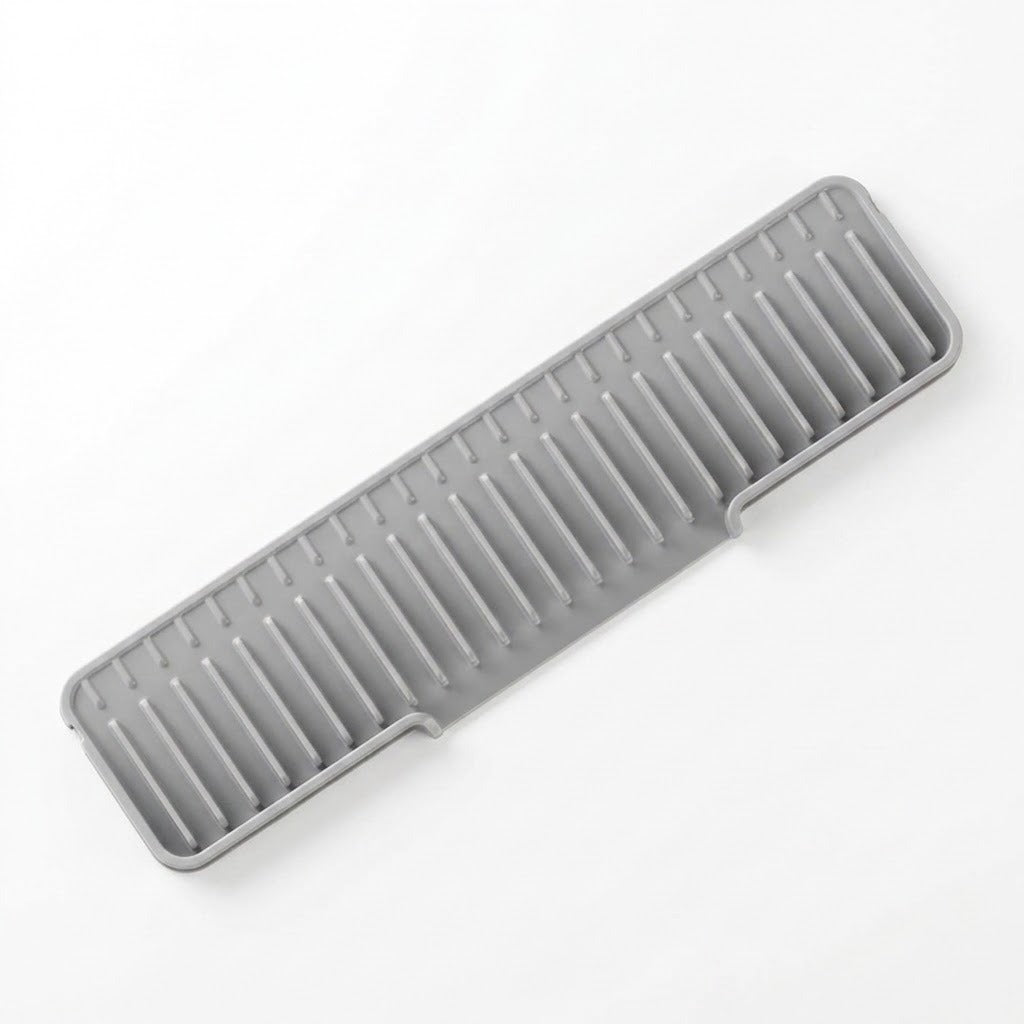 A gray silicone dish drying rack with a slotted, ribbed design, shown diagonally on a clean white background.