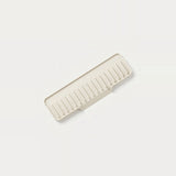 A rectangular plastic organizer tray with a slotted, ribbed design, shown at an angle on a clean, solid off-white background.