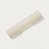 A rectangular plastic organizer tray with multiple vertical slots, shown at an angle on a clean, light off-white background.