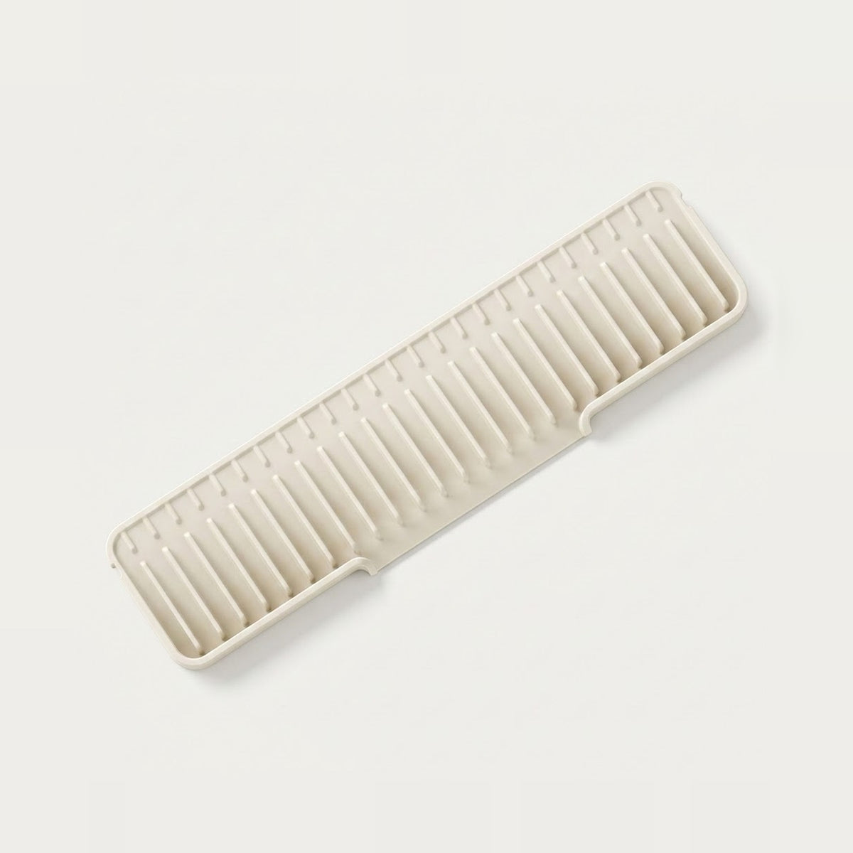 A rectangular plastic organizer tray with multiple vertical slots, shown at an angle on a clean, light off-white background.
