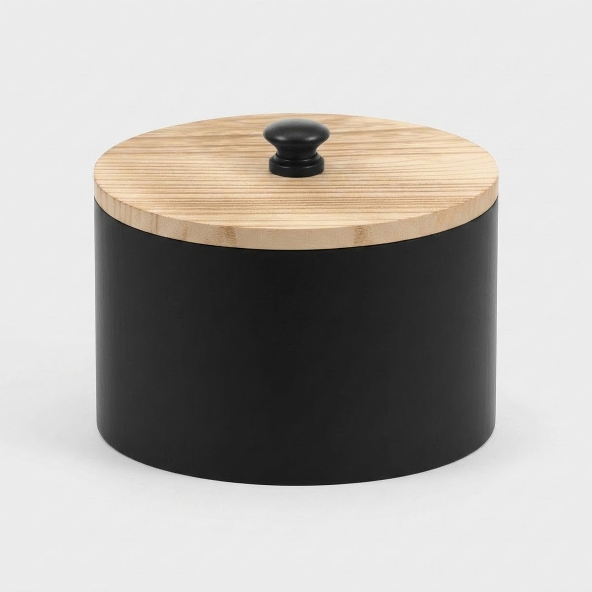 A cylindrical storage container with a matte black body and a light natural wood lid featuring a small black knob, shown on a light gray background.