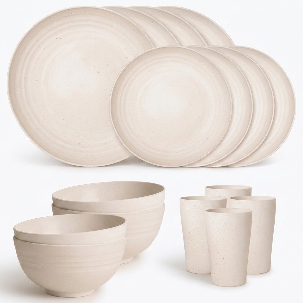 A coordinated ceramic dinnerware set in a warm off-white or cream tone, including multiple round plates, bowls, and cups, arranged on a clean white background.