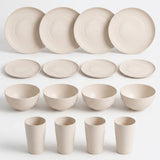 A coordinated ceramic tableware set in a warm off-white or cream tone, arranged on a light gray background. The set includes four large round plates, four smaller round plates, four bowls, and four tapered cups.