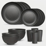 A matte black dinnerware set including plates, bowls, cups, and tumblers, arranged on a light gray background.