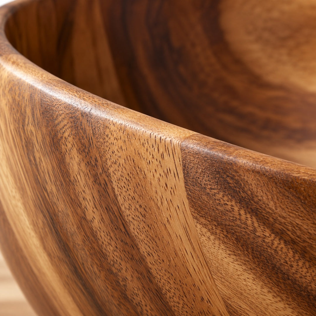 Close-up of the acacia wood salad bowl’s varied grain and smooth finish.