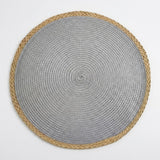 A round woven placemat with a textured silver-gray center and a natural tan braided border, shown from a top-down view on a light gray background.