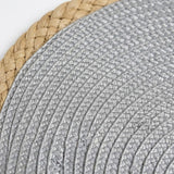 Close-up of a woven round placemat or tray, showing a light gray braided center and a natural tan straw border on a white background.