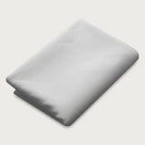 A folded light gray fabric item, likely a sheet or blanket, shown on a plain off-white background.