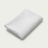 A folded white sheet or pillowcase on a clean, light off-white background.