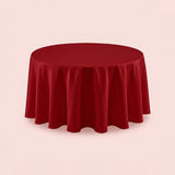 A round red tablecloth draped over a circular table, shown against a solid pale pink background.