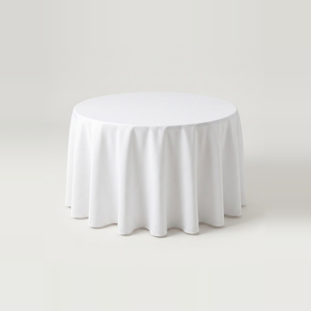 A round white tablecloth draped over a circular table, shown against a seamless light gray studio background.