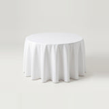 A round white tablecloth draped over a circular table, shown against a seamless light gray studio background.