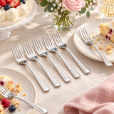 Disposable silver forks beside dessert plates show easy cutlery for a birthday table.
