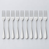Ten silver disposable forks stand in a row against a light silver studio background.