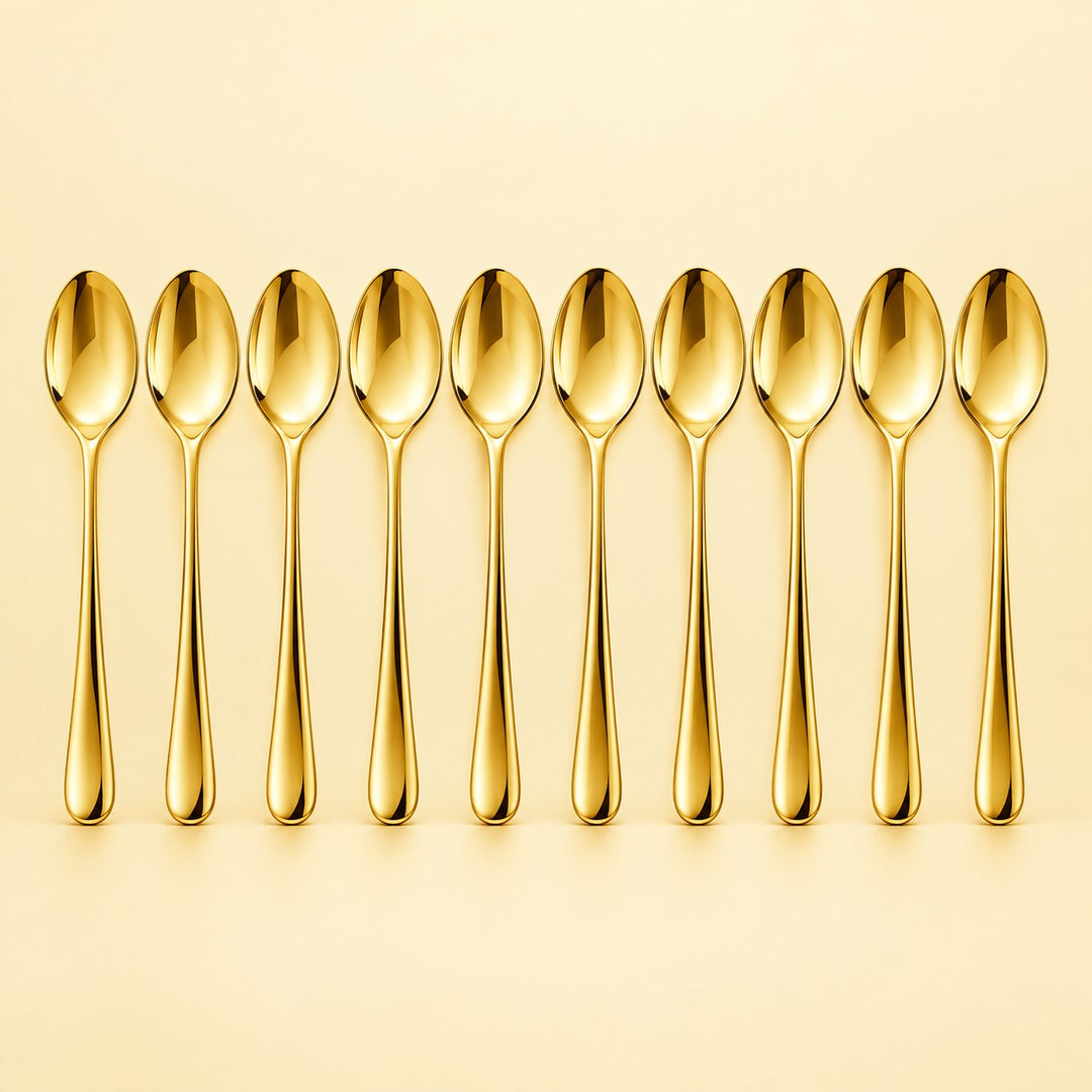 Ten gold disposable spoons stand in a row against a pale gold studio background.