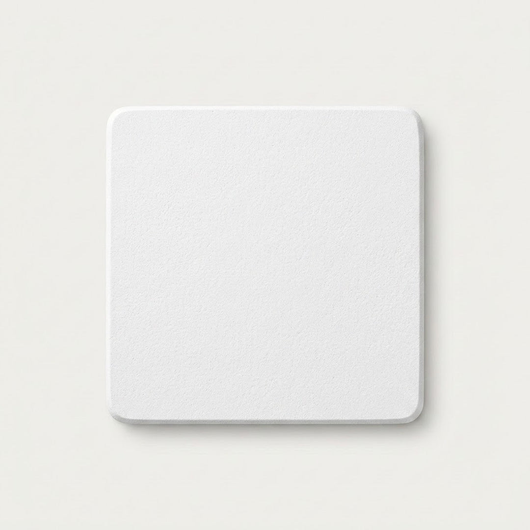 A square white coaster with rounded corners, shown from a top-down view on a light beige background.