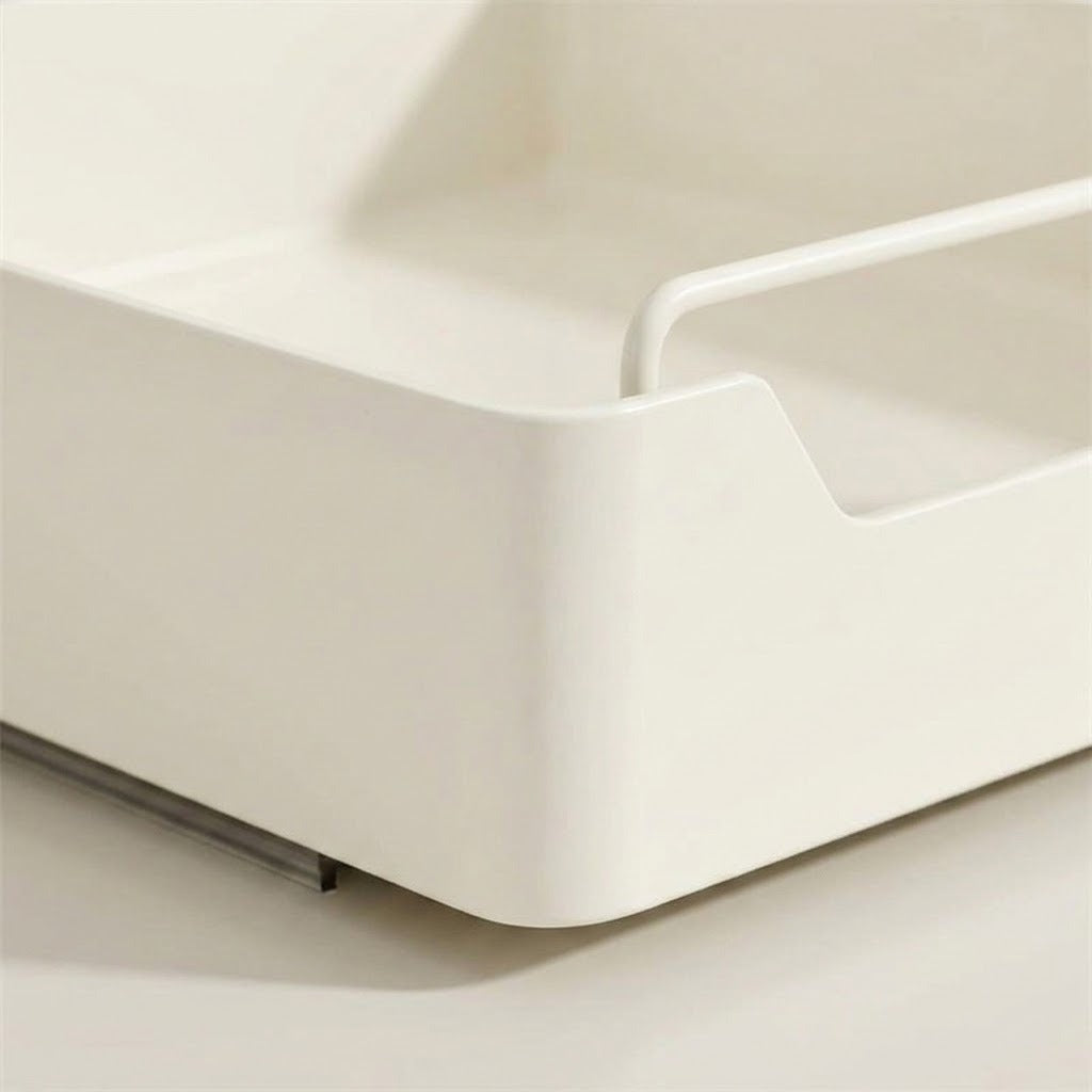 Close-up of a minimalist white plastic organizer tray with a curved handle, shown on a matching light beige background.