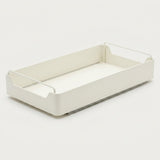 A minimalist white plastic storage tray with integrated wire handles on a clean, light off-white background.