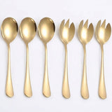 A set of six gold-colored flatware utensils, including four spoons and two forks, arranged in a row against a plain white background.
