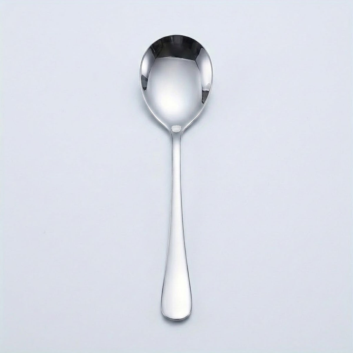 A polished stainless steel teaspoon with a reflective finish, shown vertically against a light gray background.