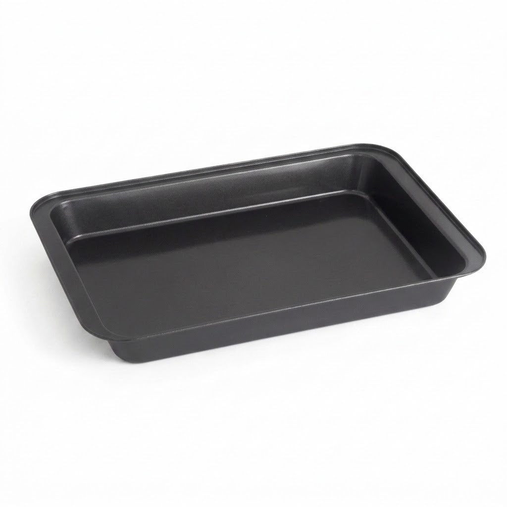 A rectangular black non-stick baking pan with raised rimmed edges, shown at an angle on a clean white background.