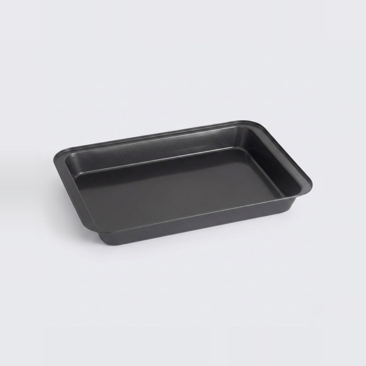 A rectangular black baking pan with raised edges, photographed on a clean light gray background.