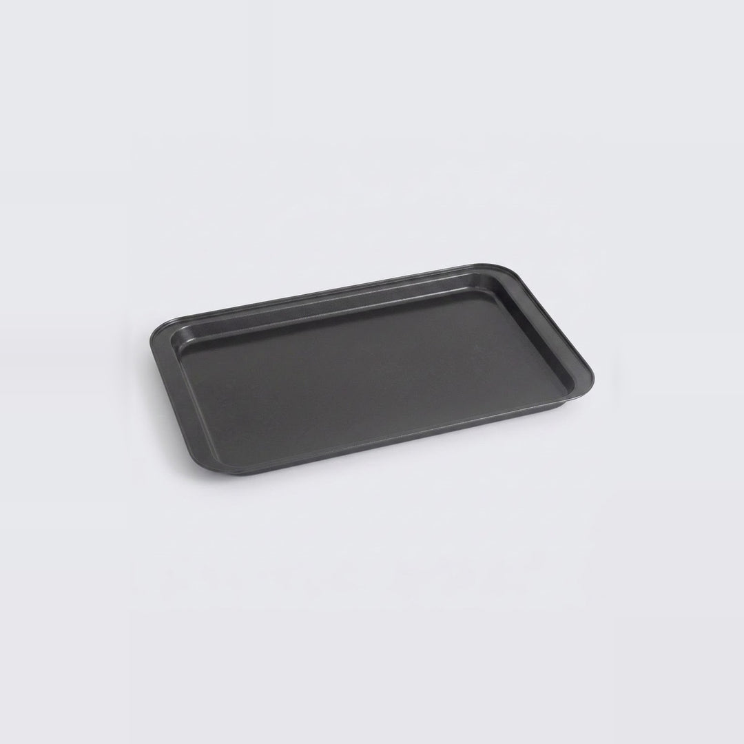 A rectangular black baking tray with raised edges, shown at an angle on a light gray background.