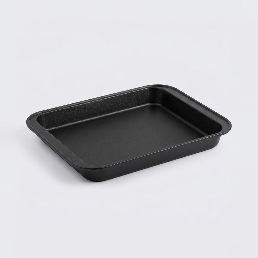 A black rectangular baking pan with rounded corners, photographed on a clean light gray background.