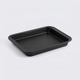 A black rectangular baking pan with rounded corners, photographed on a clean light gray background.