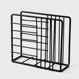 A black metal wire organizer rack with multiple vertical and horizontal bars, shown on a light gray background.