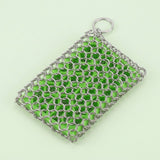 A silver metal chainmail mesh pouch with a top ring, filled with bright green beads, set against a pale mint green background.