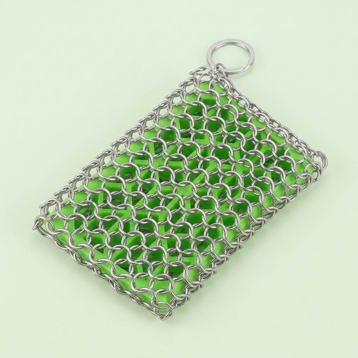 A silver metal chainmail mesh pouch with a top ring, filled with bright green beads, set against a pale mint green background.