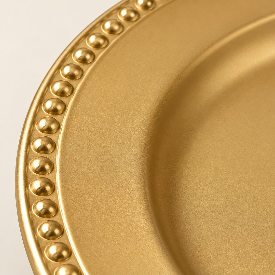 Macro detail of the Gold Beaded Charger Plate showing its smooth gold finish and beaded edge.