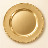 Single Gold Beaded Charger Plate centered on a pale champagne backdrop.
