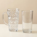 A clear glass mug with a textured geometric pattern and a handle, shown next to a matching clear glass pint tumbler on a light beige background.