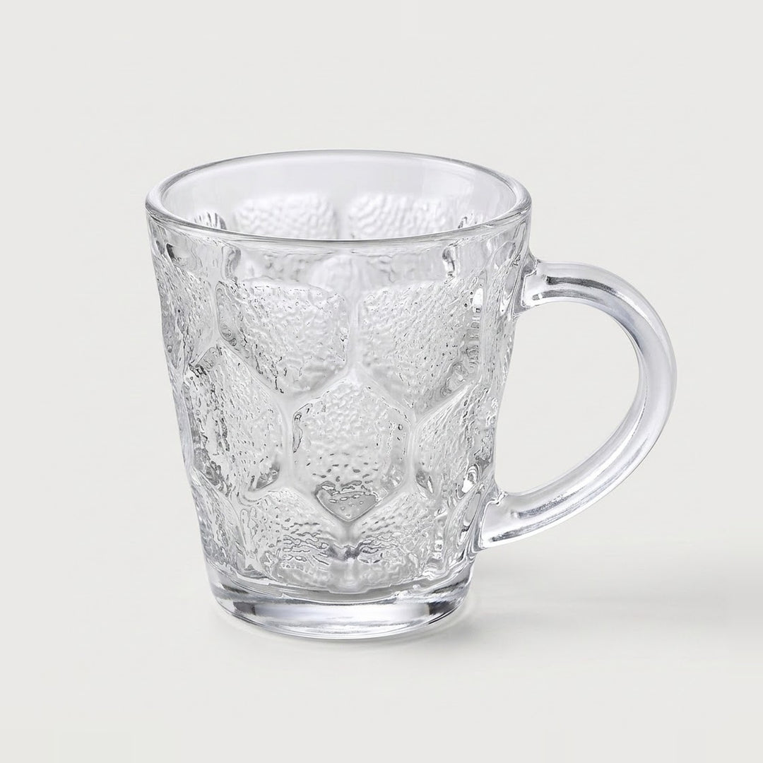 A clear textured glass mug with a honeycomb pattern and a curved handle, shown on a light gray background.