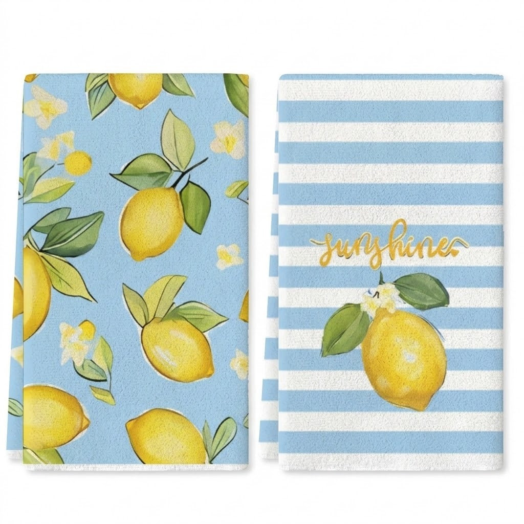 Two kitchen towels with lemon and white flower prints, one solid light blue and one light blue and white striped with gold script reading 'Sunshines'.