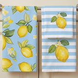 Two kitchen towels hanging on a metal rod. One towel has a light blue background with a yellow lemon and green leaf pattern, and the other has white and light blue horizontal stripes with a large yellow lemon print.