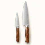 Fruit and chef knife pair with stainless blades and brown handles on a cream studio backdrop.