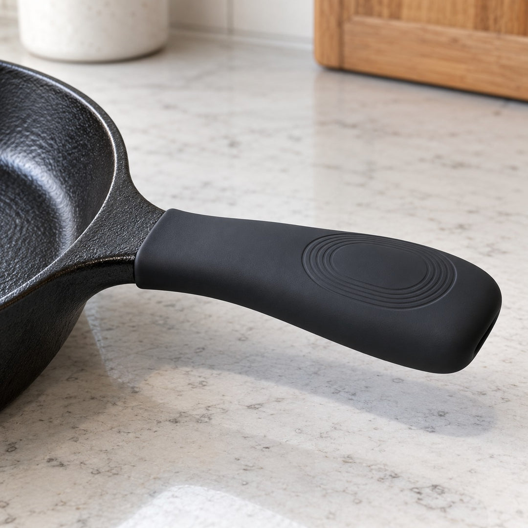 Black silicone pot handle cover fitted to a skillet highlights its molded anti-slip grip panel.