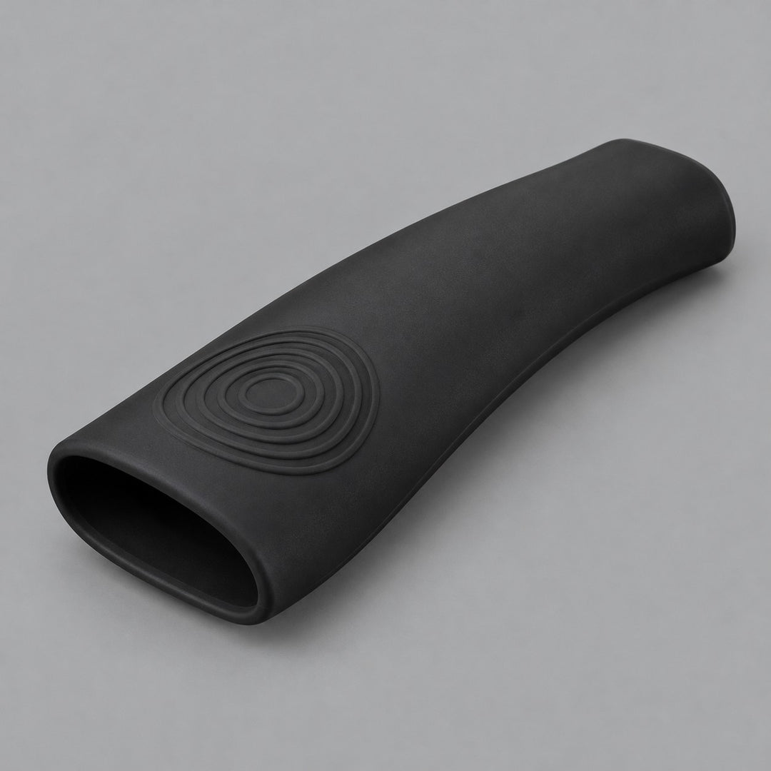 Single black silicone pot handle cover centered on a soft gray studio background.