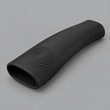 Single black silicone pot handle cover centered on a soft gray studio background.