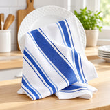 Blue striped cotton tea towel rests over a ceramic plate beside the kitchen sink for drying dishes.