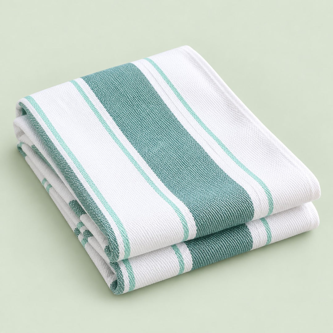 Green striped cotton tea towel folded on a soft green studio background.