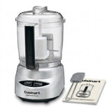 Cuisinart Mini Prep Plus food processor with a clear plastic bowl, silver base, black handle, and a small instruction booklet and spatula on a white background.