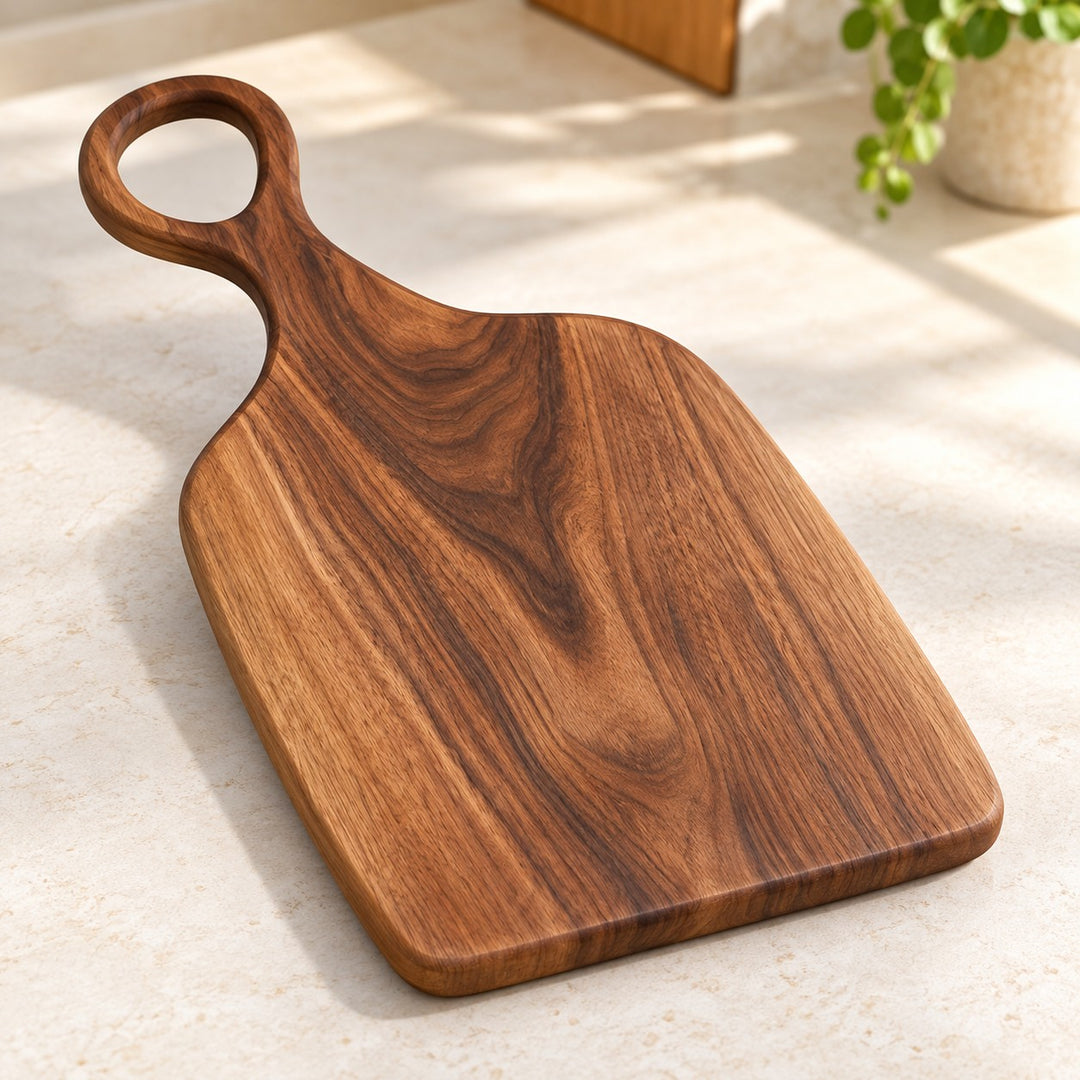 Handmade Acacia Cutting Board showing its natural acacia grain and hanging hole on a kitchen counter.